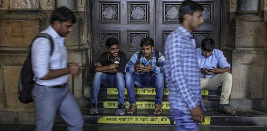 Commuters sitting outside Chhatrapati Shivaji Maharaj Terminus train station in Mumbai