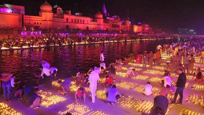 People light earthen lamps on the banks of Saryu during Deepotsav celebrations, in Ayodhya Saturday. | Photo: ANI