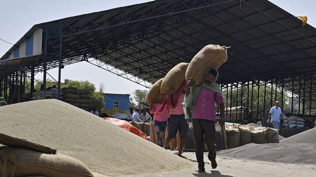 Workers load sack of Barley onto a truck at a grain market in Rewari, Haryana. | Photographer - Anindito Mukherjee | Bloomberg