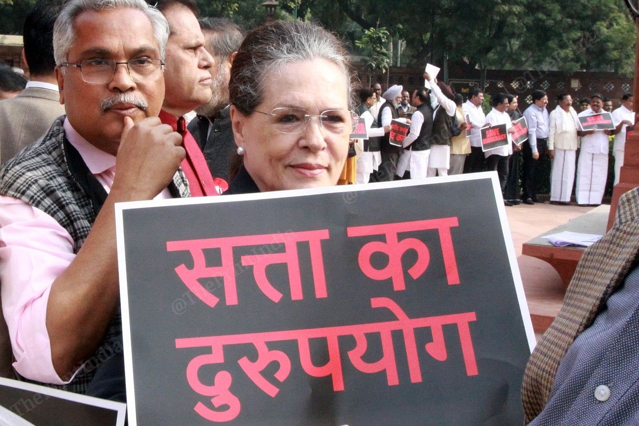 Sonia Gandhi holds up a placard, alleging misuse of power by the current government after the BJP pulled a coup in Maharashtra overnight. | Phtoto: Praveen Singh | ThePrint