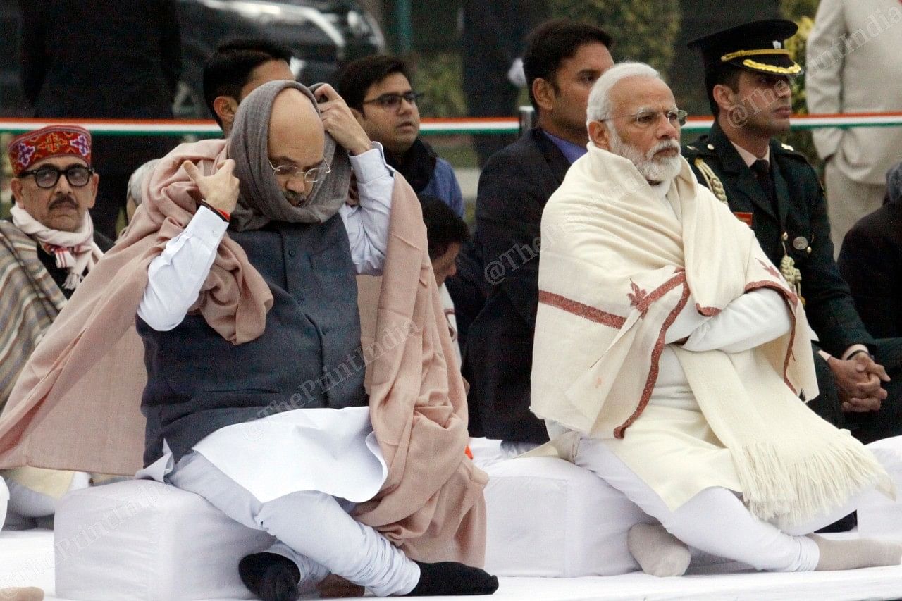 Amit Shah left) covers himself with a muffler in a chilly winter morning | Photo: Praveen Jain | ThePrint