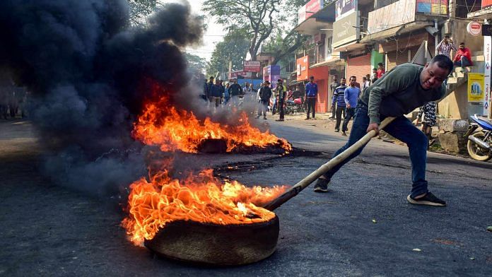 A demonstrator burns tyres on National Highway 17 during a protest rally against CAB, at Boko in Kamrup district of Assam