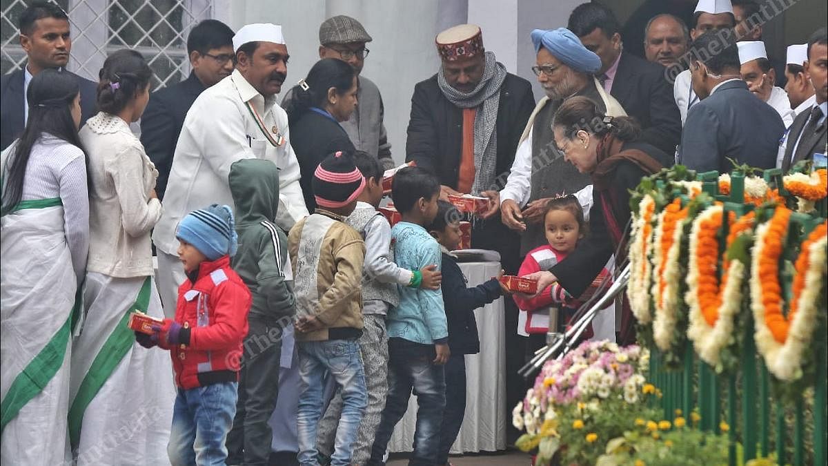 Congress leaders Sonia Gandhi and Manmohan Singh distribute sweets to children at the party headquarters in New Delhi | Photo: Suraj Singh Bisht | ThePrint