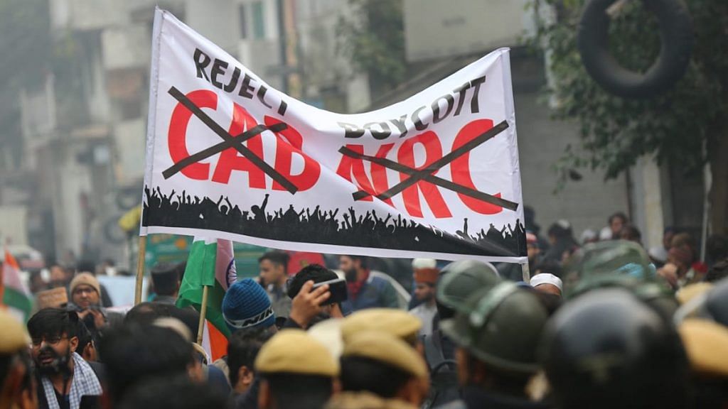 Anti-CAA protesters in Delhi lifting a banner which says reject CAB and boycott NRC.