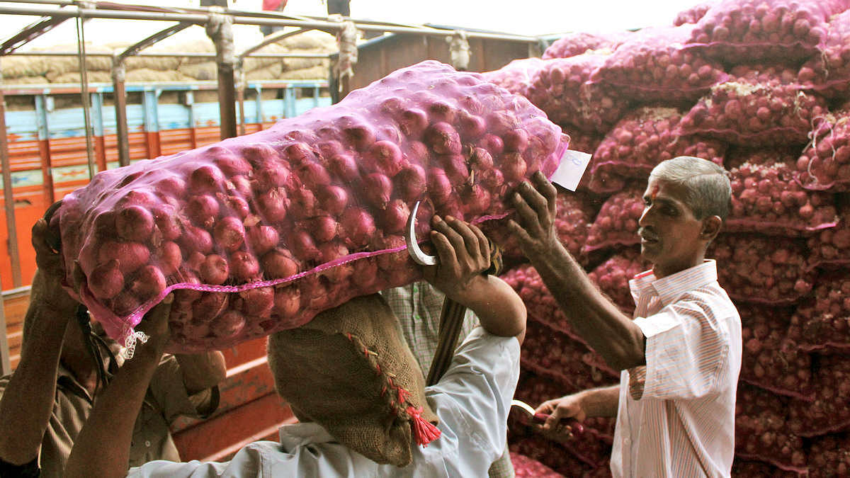 Vendors carry onion sacks at a market in Mumbai