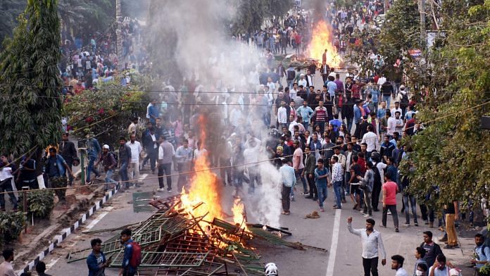 Protestors burn hoardings during their protest strike against Citizenship Amendment Bill in Guwahati