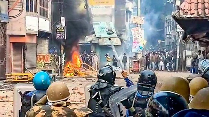 Police personnel clash with protesters demonstrating against CAA in Rampur on 21 December