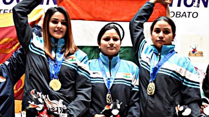 India's Gauri Sheoran, Neeraj Kaur and Annu Raj Singh hold the national flag as they win the Gold medal in 25m pistol women team