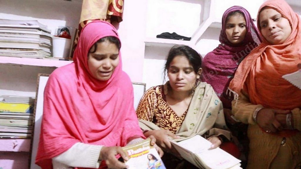Family members of Suleiman, who was killed in violence in UP's Bijnor Friday, show the books he was using to prepare for the UPSC exam | Photo: Praveen Jain | ThePrint
