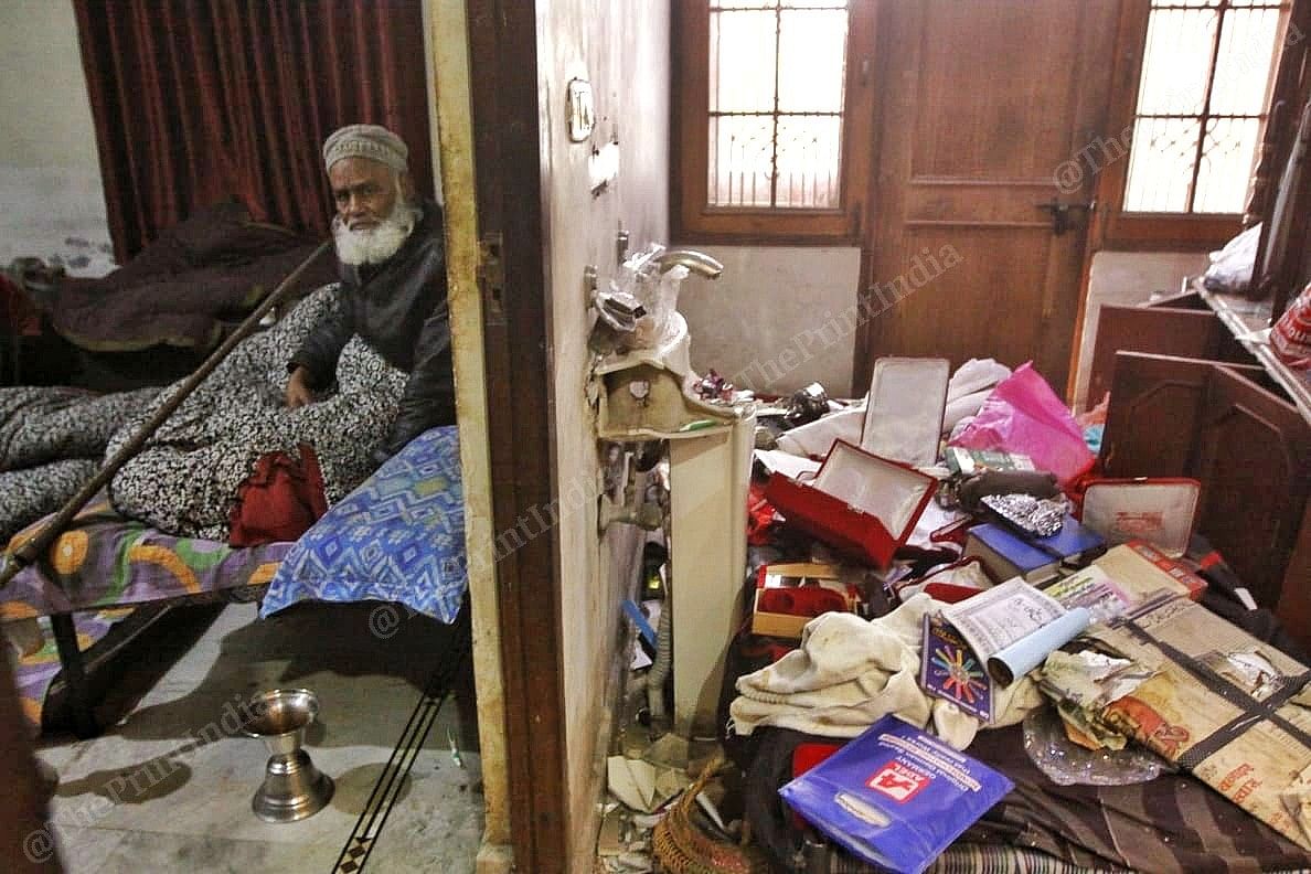 Ilahi sitting with his belongings at his home 