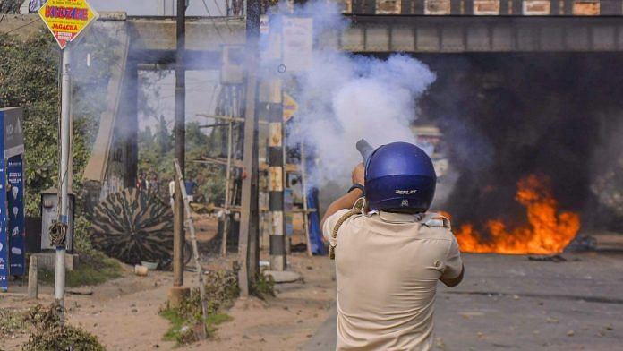 A police personnel fires tear gas to disperse protestors during a demonstration against the passing of Citizenship Amendment Bill (CAB) at Santragachi in Howrah district of West Bengal. | PTI