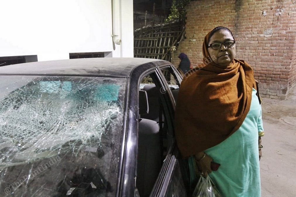 Najma Begum standing next to her smashed car. | Photo: Praveen Jain/ThePrint