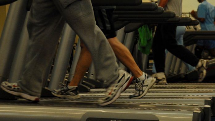 People running on a treadmill at a gym.