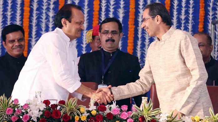 Maharashtra chief minister Uddhav Thackeray shakes hand with NCP leader and deputy CM Ajit Pawar during the swearing-in ceremony in Mumbai. | Photo: ANI