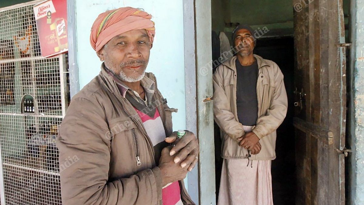Sajjan Lal (left) buys country liquor from Shyam Sundar's shop in Takiya village, Chandauli district | Photo: Praveen Jain | ThePrint