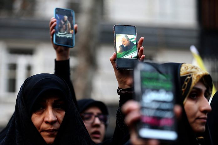 Iranian demonstrators hold up mobile phones showing the picture of the late Iranian Major-General Qassem Soleimani in front of United Nation office in Tehran