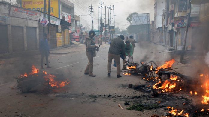 Police personnel trying to douse a fire during anti-CAA protest in Muzaffarnagar on 20 Decembe