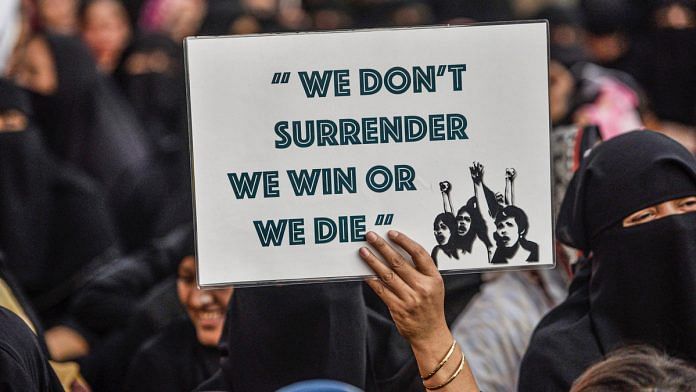 A protestor holds a placard during a demonstration against CAA and NRC in Mumbai