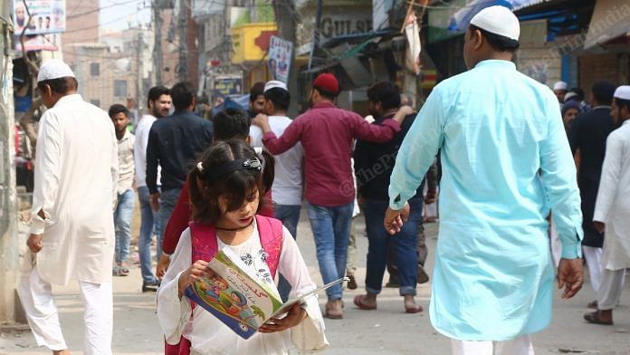 A child reads a book on the streets of Brijpuri, Northeast Delhi | Photo: Suraj Singh Bisht | ThePrint