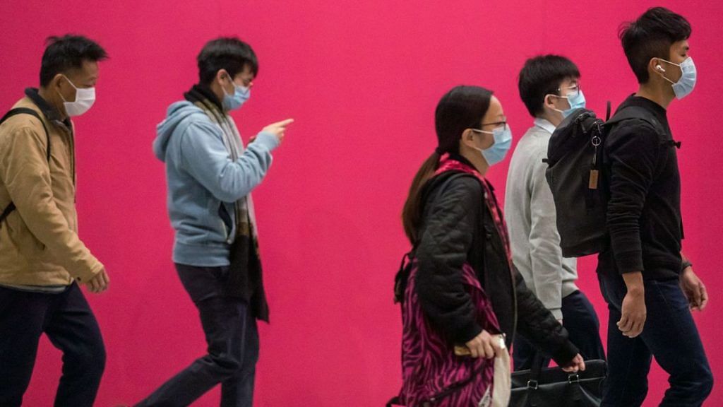 People wearing masks walk at Central district in Hong Kong, China | Paul Yeung/Bloomberg