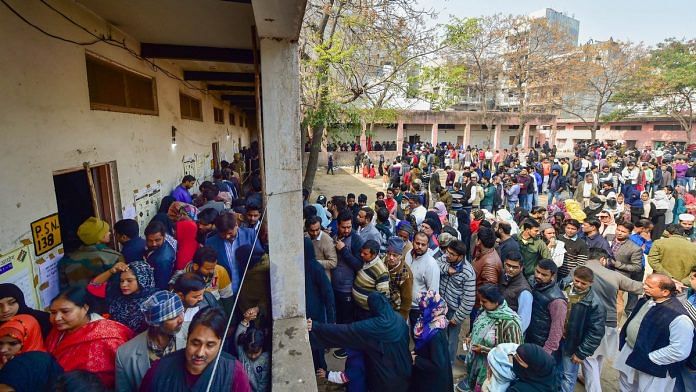 Voters wait in queues at the Abul Kalam Azad school polling station in Shaheen Bagh
