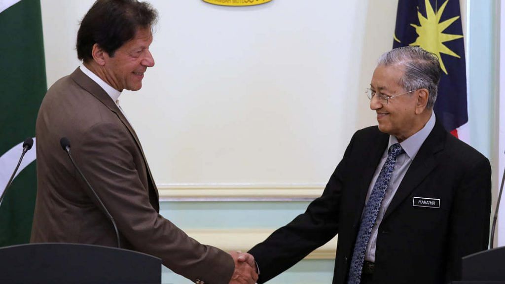 Pakistan's Prime Minister Imran Khan shakes hands with Malaysia's Prime Minister Mahathir Mohamad after a joint news conference in Putrajaya, Tuesday