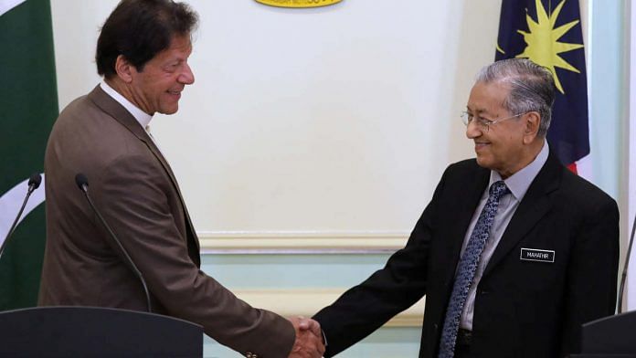 Pakistan's Prime Minister Imran Khan shakes hands with Malaysia's Prime Minister Mahathir Mohamad after a joint news conference in Putrajaya, Tuesday