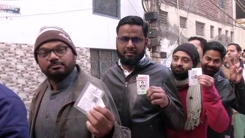 Voters standing in a queue outside a polling booth in Shaheen Bagh