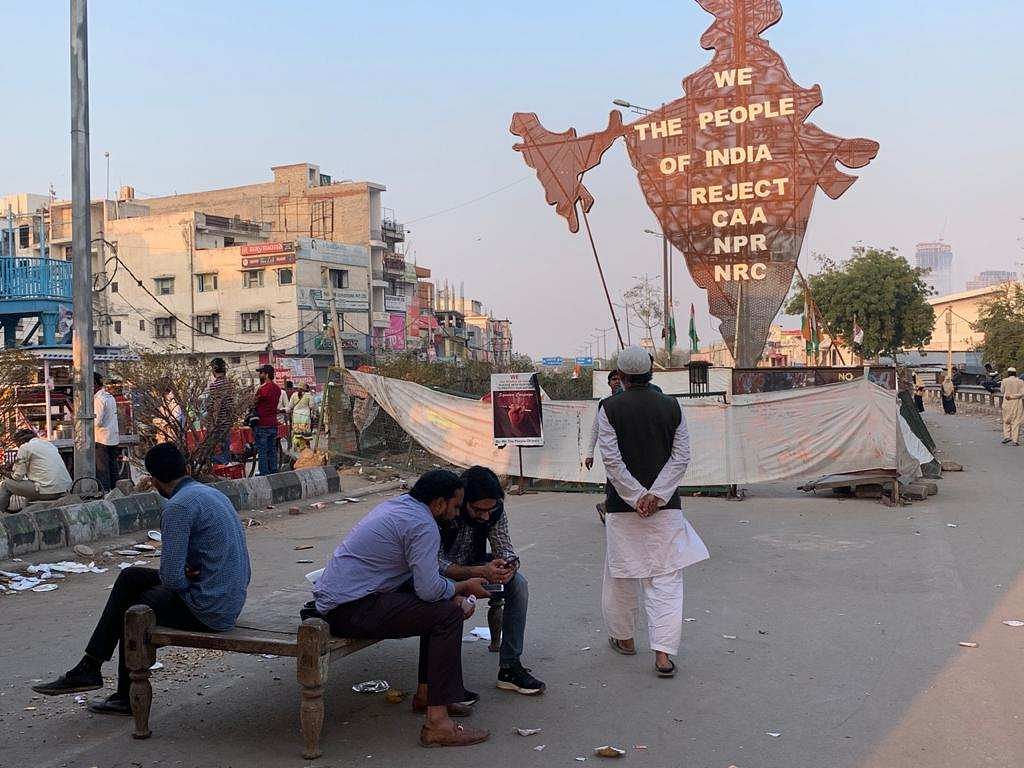 People sit near a model of India at the Shaheen Bagh protest site | Sanya Dhingra | ThePrint