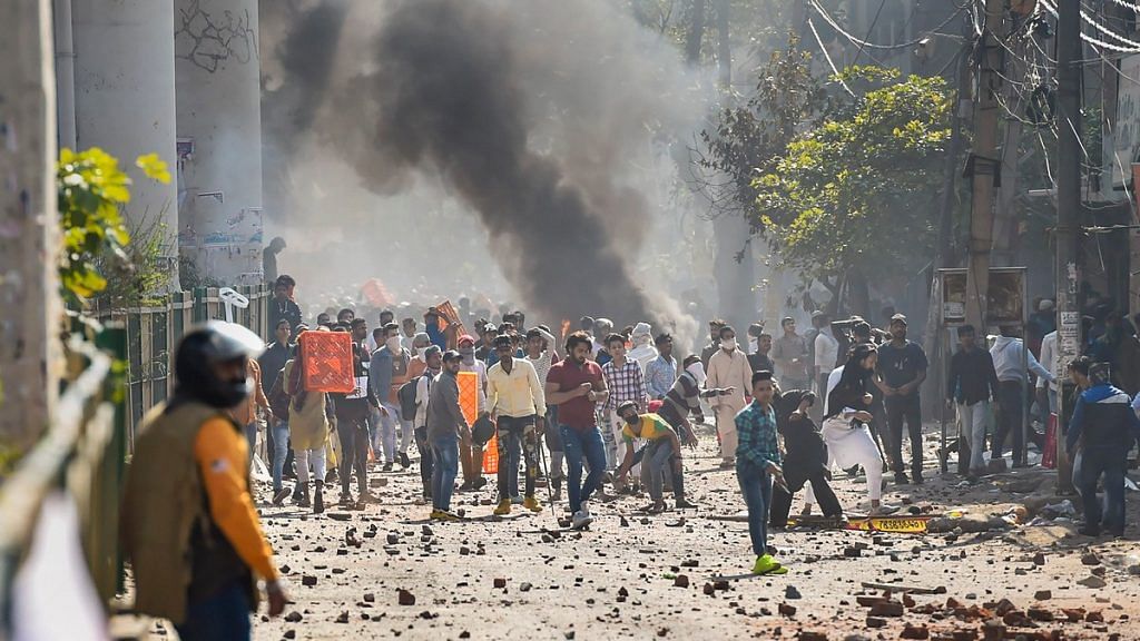 Protestors throw brick-bats during clashes between a group of anti-CAA protestors and supporters of the new citizenship act, at Jafrabad in north-east Delhi | PTI