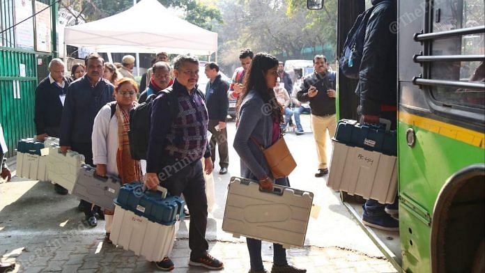 Electoral staff members collect the EVMs and VVPAT machines ahead of the Delhi Legislative Assembly Election in New Delhi on Friday | Suraj Singh Bisht | ThePrint