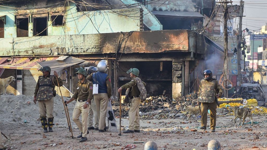 Security personnel stand guard near a neighbourhood vandalised by rioters during clashes between those against and those supporting the Citizenship (Amendment) Act in north east Delhi, Tuesday, Feb. 25, 2020. | PTI