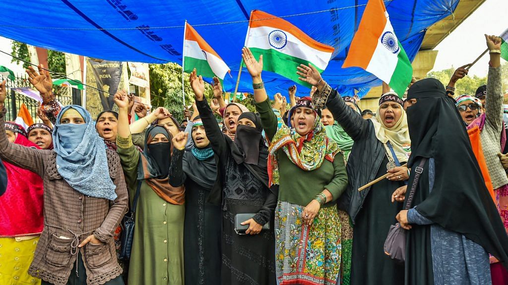Protestors holding Tricolour flags raise slogans during a protest against CAB, NCR, NPR at Jamia college, in New Delhi | PTI