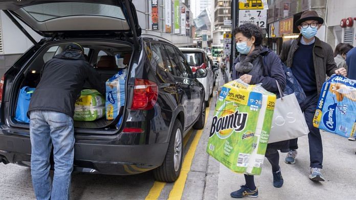 People carry newly purchased toilet paper and tissue onto the trunk of a vehicle in Hong Kong, China amid the spread of Coronavirus | Photographer: Justin Chin | Bloomberg