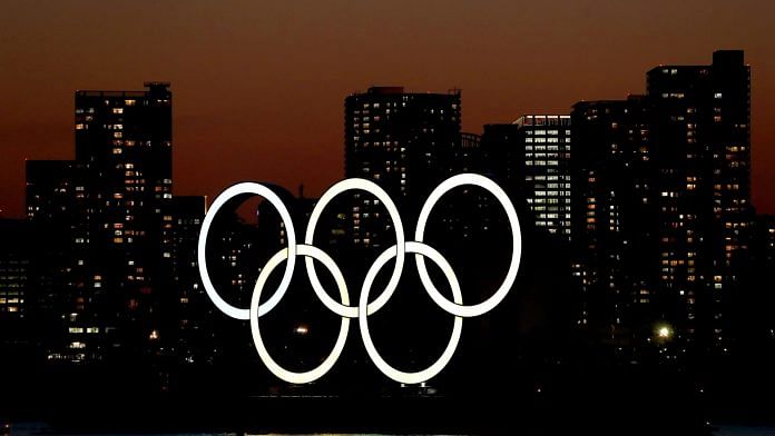 The sun sets behind the Olympic rings installation at Odaiba Marine Park on March 18, 2020 in Tokyo, Japan | Photographer: Clive Rose/Getty Images AsiaPac | Bloomberg