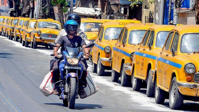 A biker rides past taxis parked along the road amid the nationwide lockdown due to coronavirus, in Kolkata | Representational image | PTI