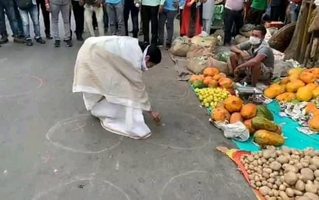West Bengal CM Mamata Banerjee draws circles at a Kolkata market to emphasise social distancing 