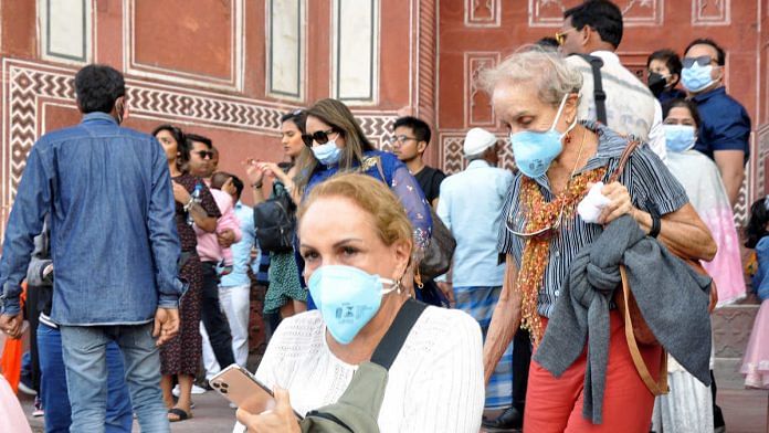 Foreign tourists wear protective masks at the Taj Mahal complex in Agra amid the coronavirus threat | Photo: ANI