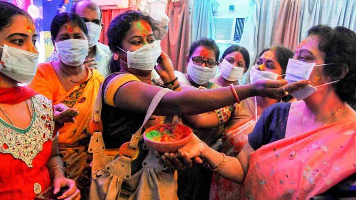 Members of a Kolkata NGO play Holi while wearing masks last week amid the coronavirus outbreak