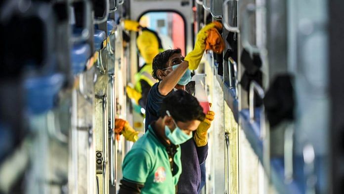 Railway workers disinfect coaches of the Delhi-Jammu Rajdhani Express train as a measure against the coronavirus pandemic, at New Delhi Railway Station, on 15 March 2020 | Arun Sharma | PTI