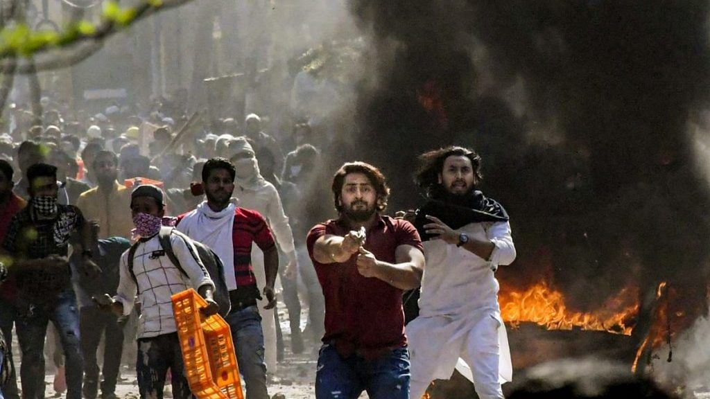 One of the viral images of Shahrukh (in red shirt) pointing his pistol during the Delhi riots in Jaffrabad | Photo: PTI