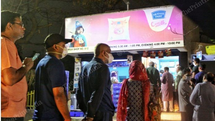 People queue up outside a dairy booth shortly after PM Modi announced a nationwide lockdown Tuesday evening