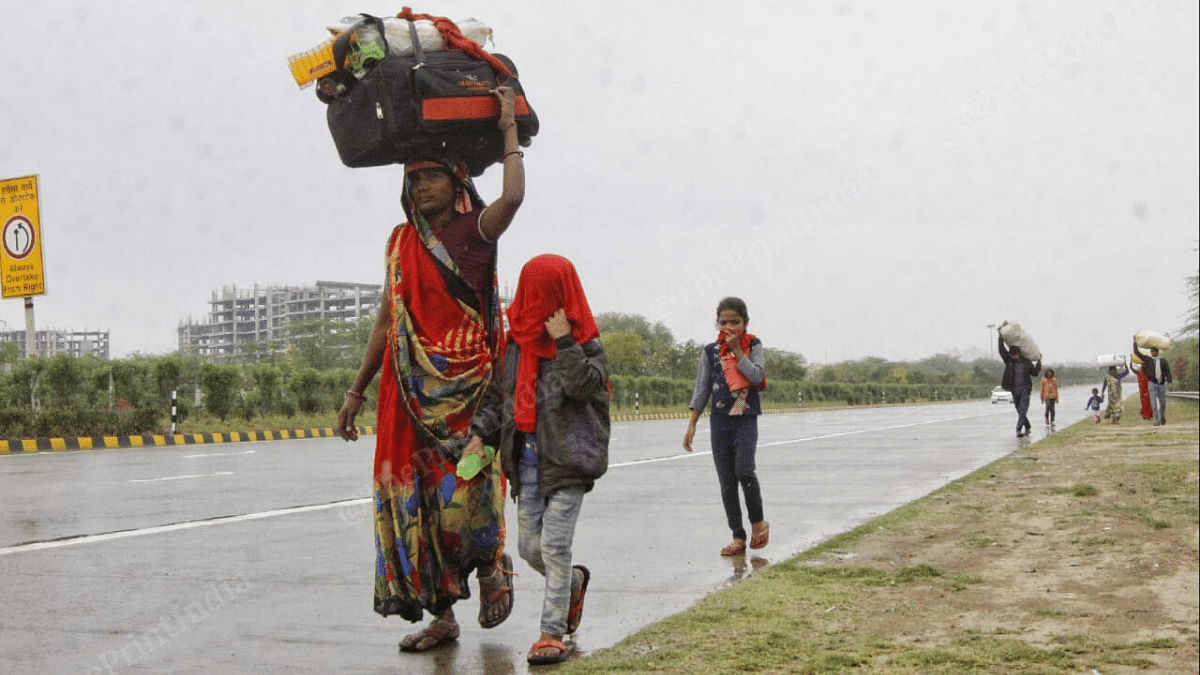 Scenes such as this — a woman, luggage in hand and leading her children — have been a common sight for the past few days as migrants head to the Delhi-Ghaziabad border to catch buses to their villages | Photo: Suraj Singh Bisht | ThePrint