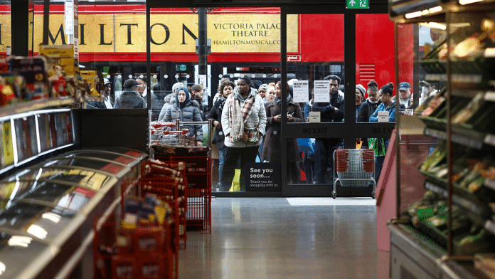 Shoppers wait for a store to open in London