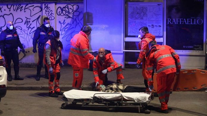 Medical personnel help a man who was lying unconscious on the ground in Rome, Italy on 22 March