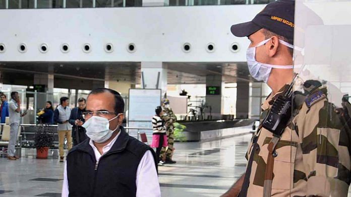 Security personnel and passengers wear masks to mitigate the spread of coronavirus at Raja Bhoj Airport in Bhopal, Friday I