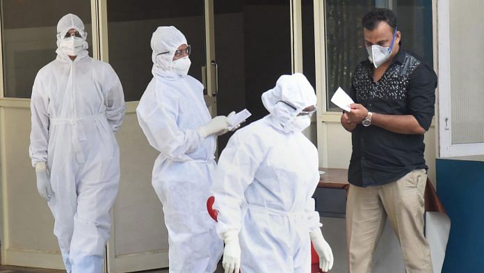Medical staff members wear masks and protective suits outside an isolation ward in Kochi | PTI Photo