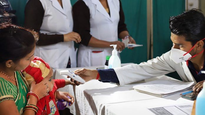 A medic conducts screening of a patient as part of precautionary measure against coronavirus, at a government hospital in New Delhi | PTI Photo