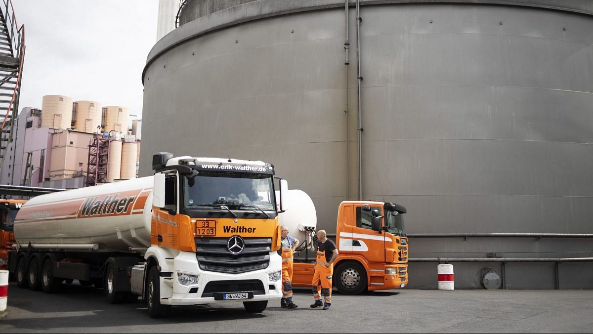 Oil Deliveries On The River Rhine Oil tanker trucks sit parked beside storage silos at the Erik Walther GmbH oil terminal on the River Rhine in Schweinfurt, Germany. | Photographer: Alex Kraus | Bloomberg