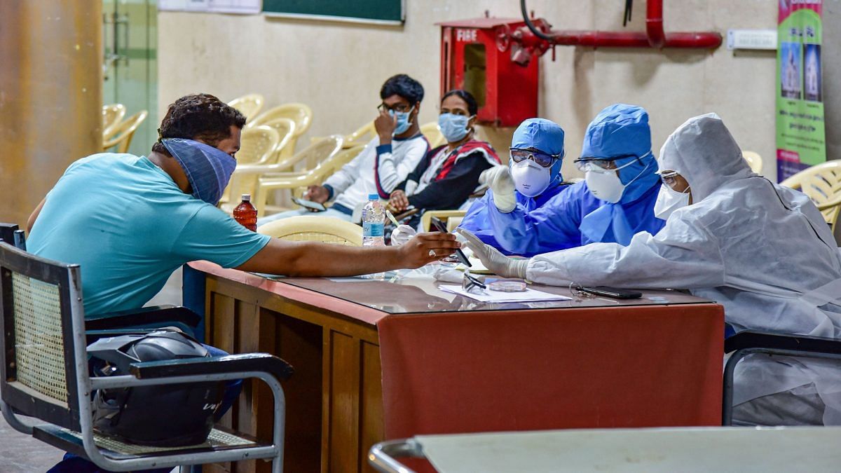 Medics interact with a patient at a help desk, set- up in view of coronavirus pandemic, at Gandhi Hospital in Hyderabad on 14 March